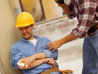 Worker holding injured arm on job site.